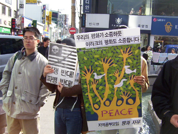 해골이 그려진 성조기 그림을 들고있는 학생. 쑥쓰러운지 얼굴을 가렸다. 